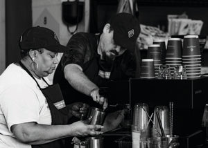 Two baristas making coffee 