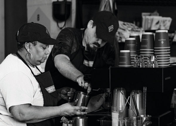 Two baristas making coffee 