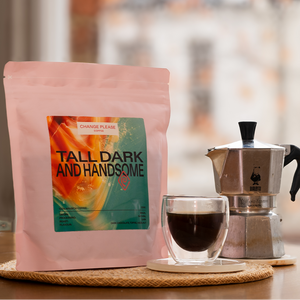 Coffee bag labeled 'Tall Dark and Handsome' with a glass of coffee and Moka pot on a wooden surface.